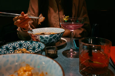 Midsection of man having food on table in restaurant
