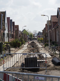 Street by buildings in city against sky