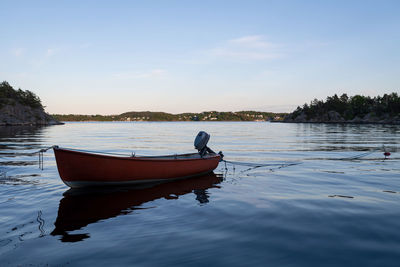 Boat moored on lake against sky