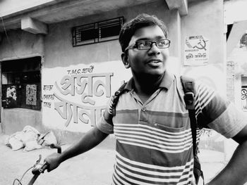 Portrait of young man standing against wall