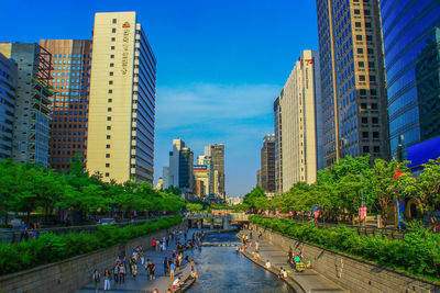 Panoramic view of buildings in city against blue sky