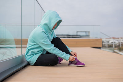 Side view of man sitting on floor