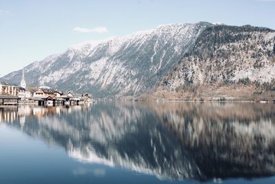 Scenic view of lake by snowcapped mountains against sky