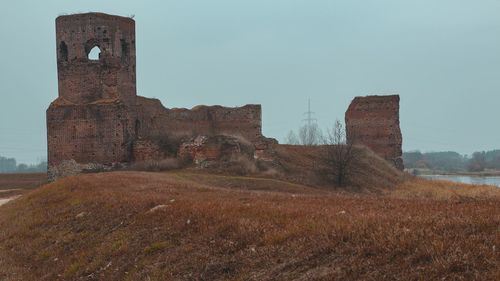 Old ruin building on field against clear sky