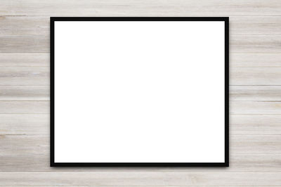 Close-up of white paper on table against wall