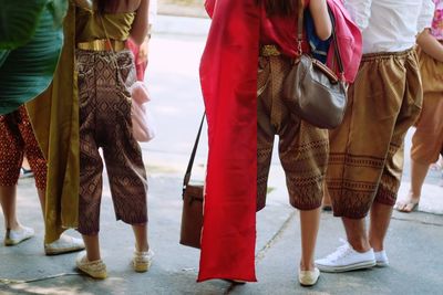 Low section of women standing on road