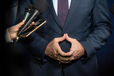 Midsection of businessman holding book