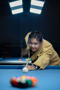 Young woman playing pool