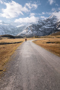 Road amidst field against sky