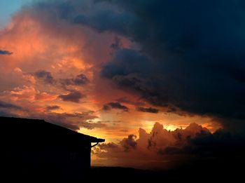 Silhouette of built structure against dramatic sky