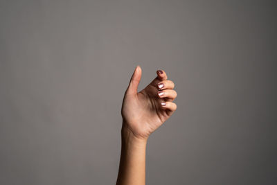 Close-up of woman hand against gray background