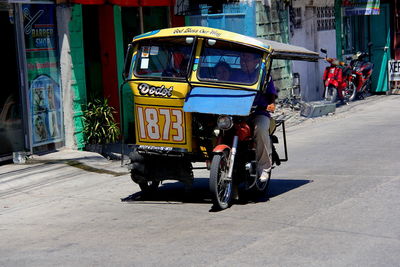 Man driving jinrikisha on city street