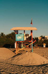 Lifeguard hut on beach against clear sky