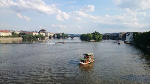 Scenic view of river by buildings against sky