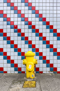 Fire hydrant on tiled floor against wall