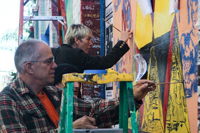 Young man looking away against graffiti