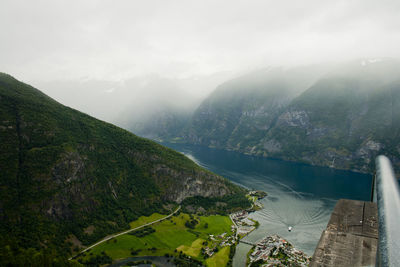 High angle view of river amidst mountains against sky