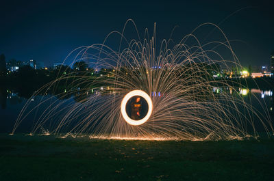 Man seen through wire wool against sky at night