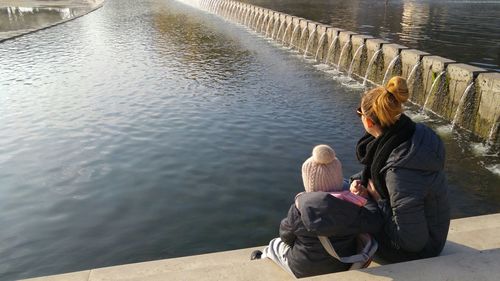 Women and child sitting by lake