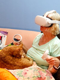 Side view of  elderly woman with cat wearing vr headset 