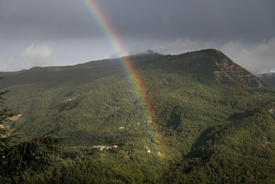 Scenic view of rainbow over mountain against sky