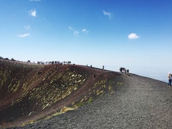 People walking on mountain against sky