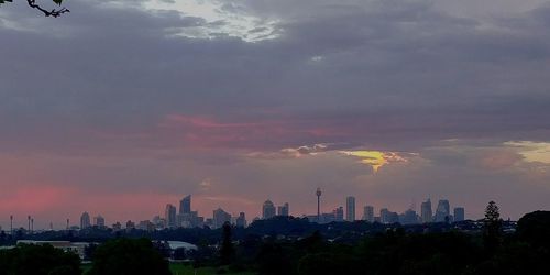Aerial view of buildings in city against sky during sunset