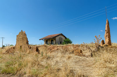 Old building on field against clear blue sky