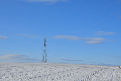 Electricity pylon on land against sky