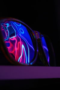 Close-up of illuminated light bulb against black background