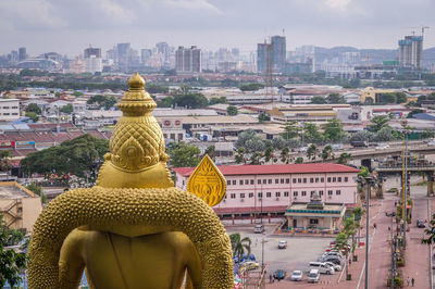 Buddha statue against buildings in city