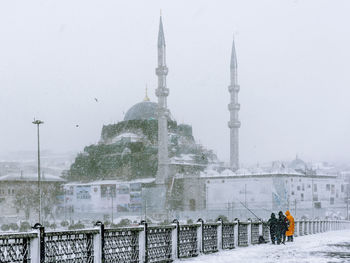 View of communications tower in city during winter