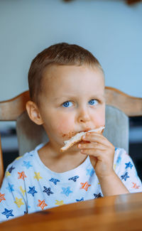 Portrait of boy eating food on table