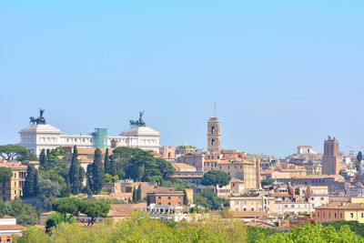 Buildings in city against blue sky