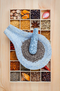 Directly above shot of colorful spices in container on wooden table