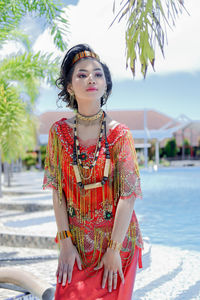 Portrait of young woman standing at beach