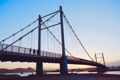 Low angle view of al ayjah bridge over sea against clear sky