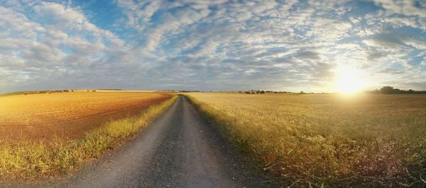 Scenic view of field against cloudy sky