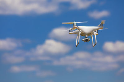 Low angle view of drone flying against sky