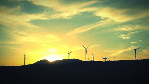 Silhouette of wind turbines at sunset