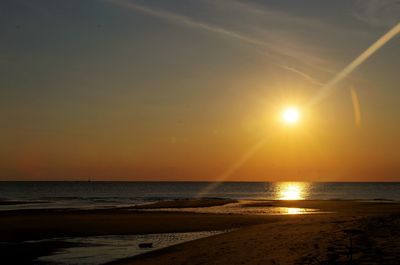 Scenic view of beach against sky during sunset