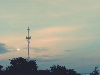 Low angle view of communications tower against sky during sunset