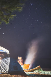 Illuminated tent on field against sky at night