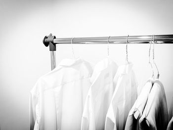 Close-up of clothes hanging on rack against white background