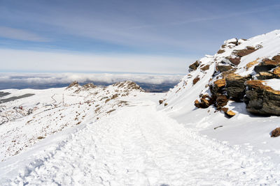 Scenic view of snow covered land against sky