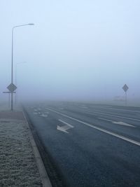 Road in foggy weather against sky during winter