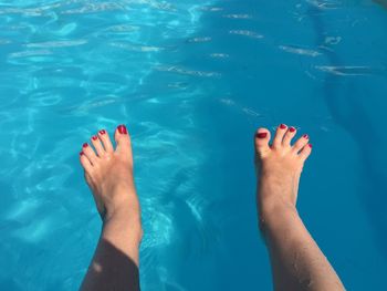 Low section of woman feet in swimming pool