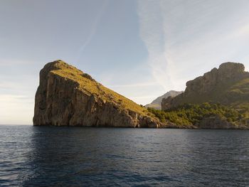 Scenic view of sea by cliff against sky