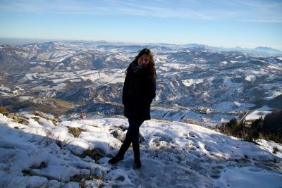 Portrait of woman standing on cliff during winter