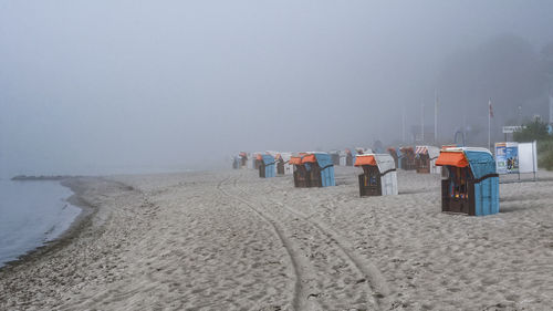 Seats on calm beach against clear sky